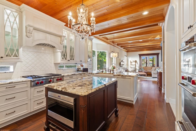 kitchen featuring tasteful backsplash, appliances with stainless steel finishes, a peninsula, wooden ceiling, and an inviting chandelier