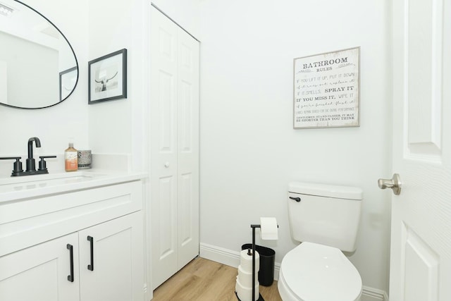 bathroom with hardwood / wood-style floors, vanity, and toilet