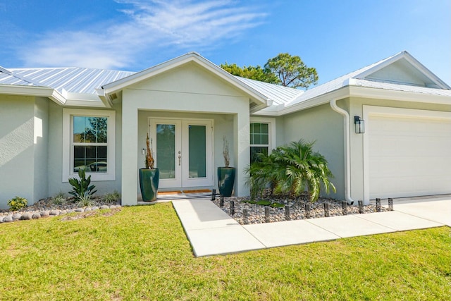 view of front facade featuring a front yard, french doors, and a garage