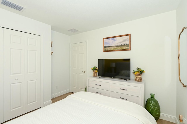 bedroom with light hardwood / wood-style floors and a closet