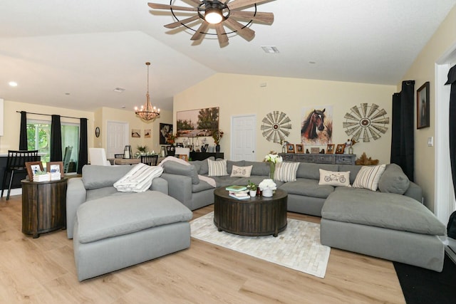 living room featuring ceiling fan with notable chandelier, light hardwood / wood-style floors, and lofted ceiling