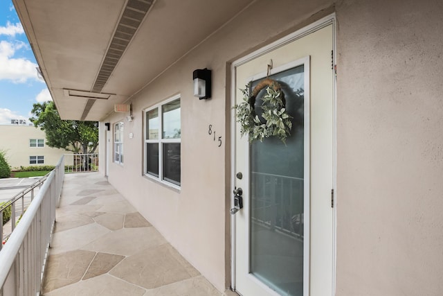 view of exterior entry with a balcony