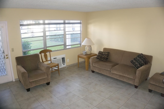 living room featuring light tile patterned floors, a textured ceiling, and an AC wall unit