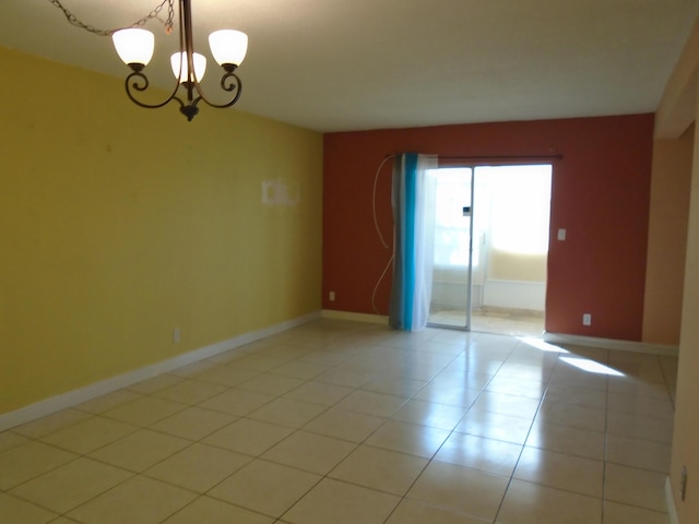 unfurnished room featuring light tile patterned floors and an inviting chandelier