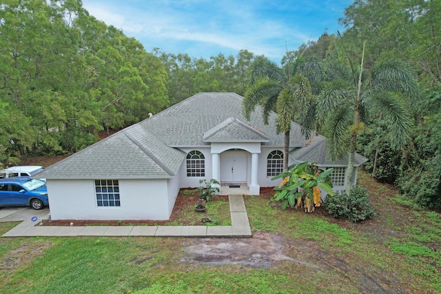 view of front of home featuring a shingled roof and stucco siding