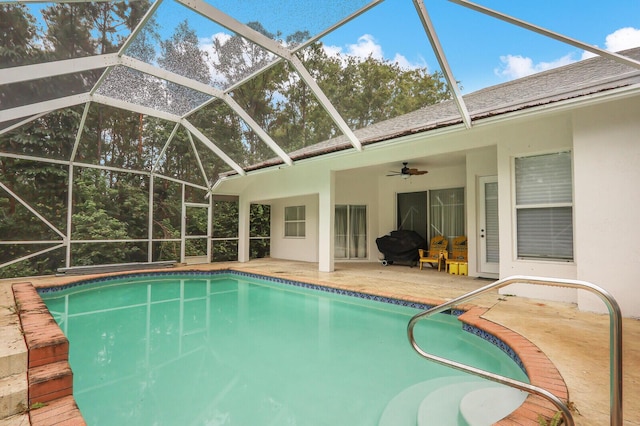 view of swimming pool featuring ceiling fan, a patio area, and a lanai