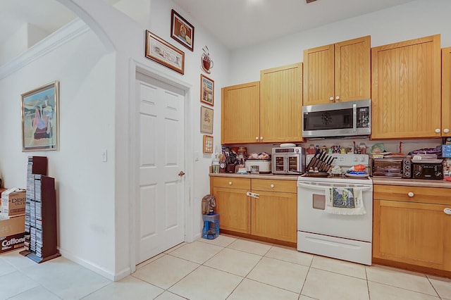 kitchen with white range with electric stovetop and light tile patterned flooring