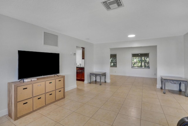 tiled living room featuring a textured ceiling