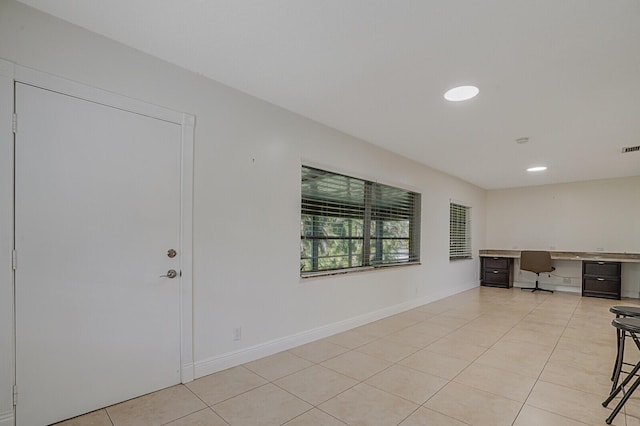 foyer featuring built in desk and light tile patterned floors