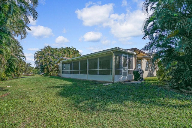 view of home's exterior featuring a yard and a sunroom