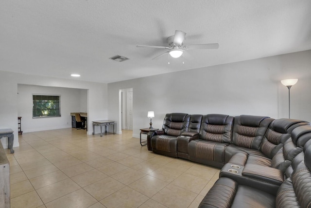 living room featuring ceiling fan, light tile patterned floors, and a textured ceiling