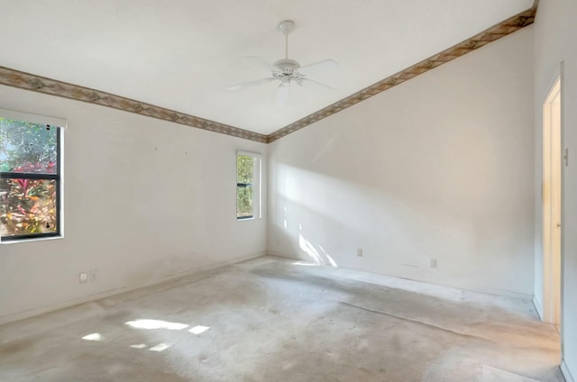 empty room featuring ceiling fan, unfinished concrete floors, and lofted ceiling