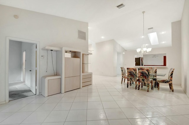 dining room with a notable chandelier, visible vents, light tile patterned flooring, and vaulted ceiling