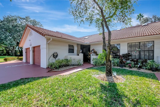 view of front of house with a tile roof, stucco siding, a garage, and a front lawn