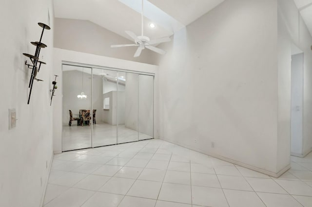 unfurnished bedroom with tile patterned floors, baseboards, a closet, high vaulted ceiling, and a ceiling fan