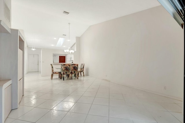 unfurnished dining area with light tile patterned floors, a chandelier, and vaulted ceiling