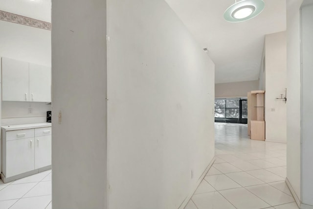 hallway featuring light tile patterned flooring and baseboards