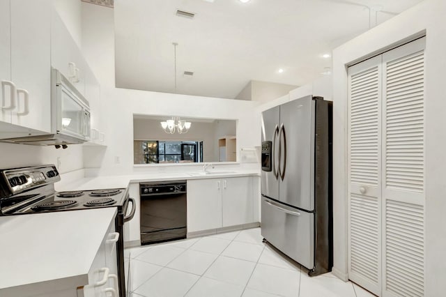 kitchen with a sink, black appliances, white cabinets, light countertops, and decorative light fixtures