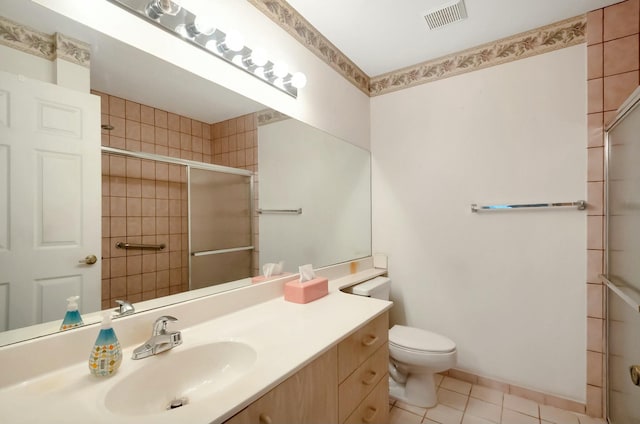 bathroom with vanity, visible vents, tiled shower, tile patterned flooring, and toilet