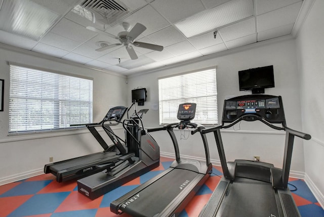 workout room featuring a paneled ceiling, ornamental molding, and ceiling fan