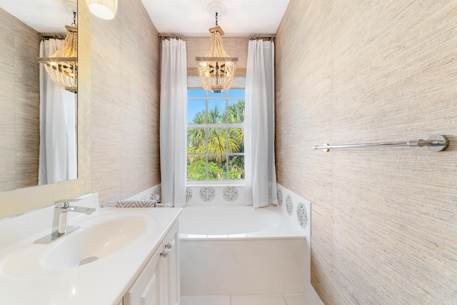 bathroom featuring a bathtub, vanity, a notable chandelier, and tile patterned flooring