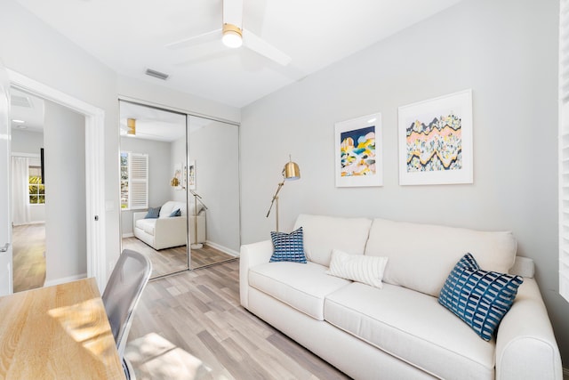 living room with light hardwood / wood-style flooring and ceiling fan