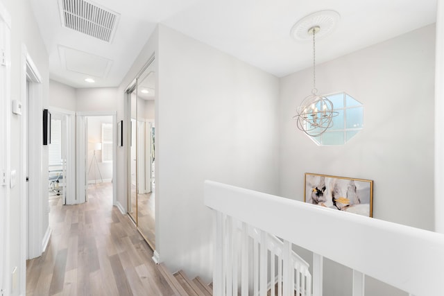 hallway featuring hardwood / wood-style floors and a notable chandelier