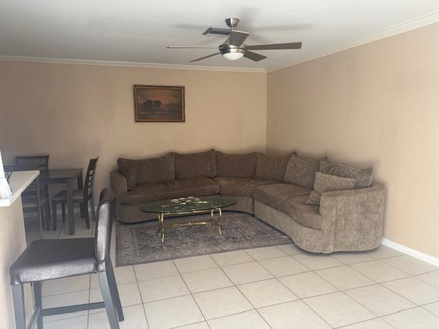 tiled living room with crown molding and ceiling fan