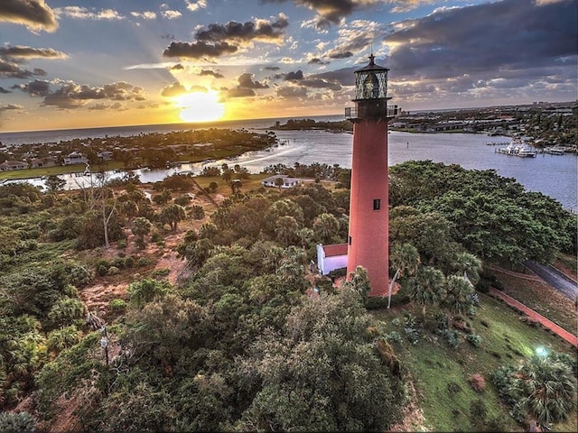 aerial view at dusk featuring a water view