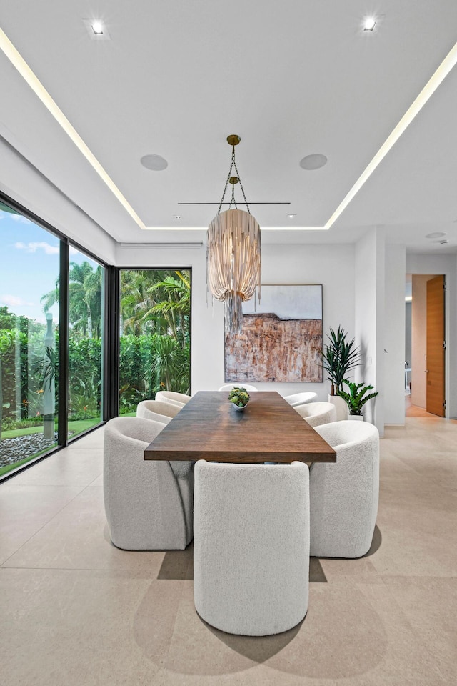 dining space with a tray ceiling and an inviting chandelier