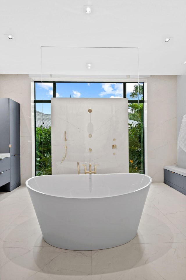 bathroom with a tub to relax in and floor to ceiling windows