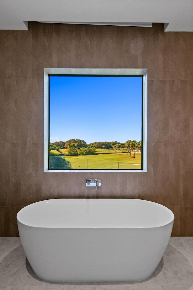 bathroom featuring a tub to relax in and a healthy amount of sunlight