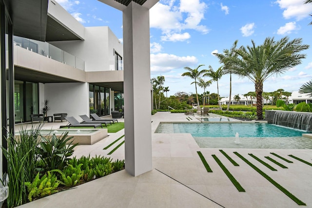 view of pool featuring a patio area, pool water feature, and an in ground hot tub