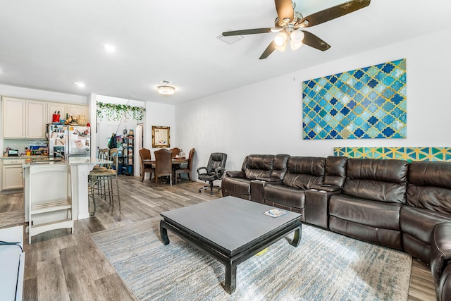 living room with light wood-type flooring and ceiling fan