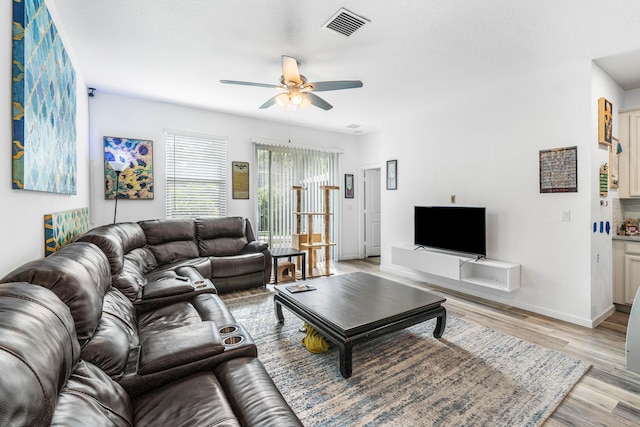 living room featuring ceiling fan and light hardwood / wood-style flooring