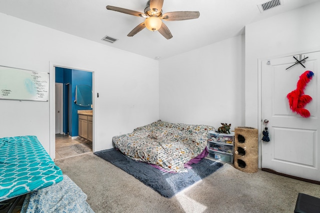 carpeted bedroom featuring ceiling fan and ensuite bathroom