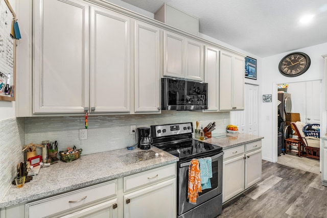 kitchen with decorative backsplash, light stone countertops, hardwood / wood-style floors, and stainless steel appliances