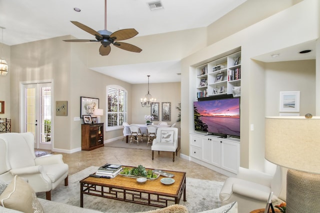 tiled living room with built in shelves and ceiling fan with notable chandelier