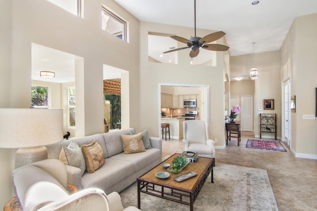 living room featuring a towering ceiling and ceiling fan