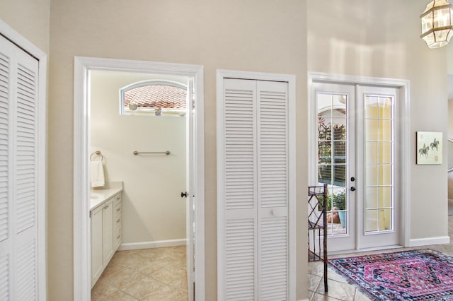 bathroom with vanity, a wealth of natural light, tile patterned floors, and a chandelier