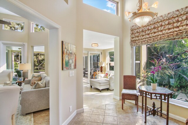 hallway with light tile patterned floors and an inviting chandelier