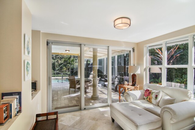 kitchen with a towering ceiling, sink, appliances with stainless steel finishes, light stone counters, and cream cabinets