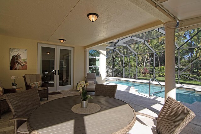 view of patio / terrace with a lanai, a pool with hot tub, and area for grilling