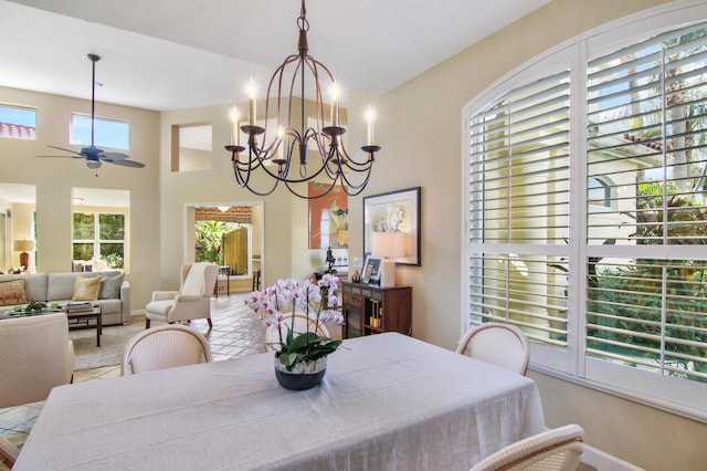 dining area featuring ceiling fan with notable chandelier