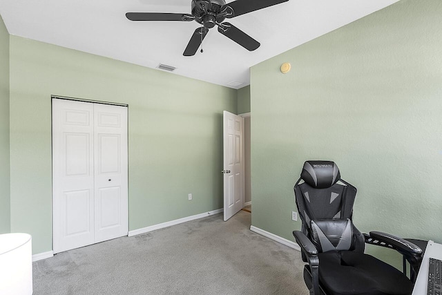 carpeted office space featuring ceiling fan