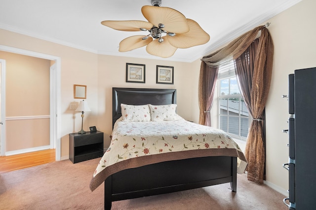 bedroom with ceiling fan, ornamental molding, and carpet floors