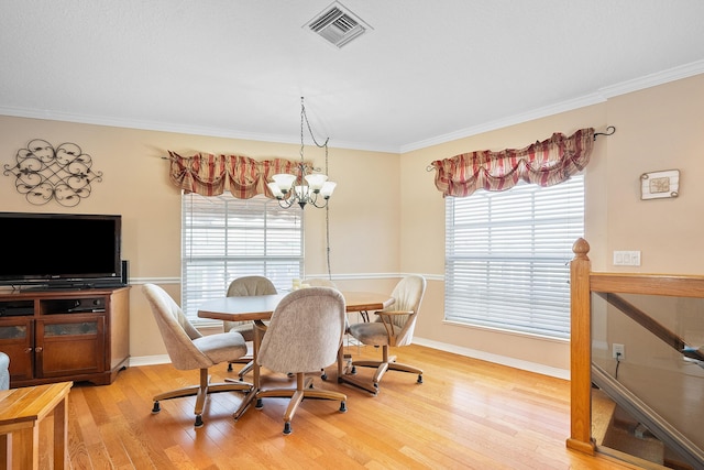 dining area with wood-type flooring, an inviting chandelier, and a healthy amount of sunlight