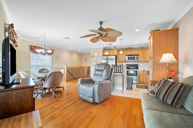 living room featuring ceiling fan with notable chandelier, light hardwood / wood-style flooring, and ornamental molding