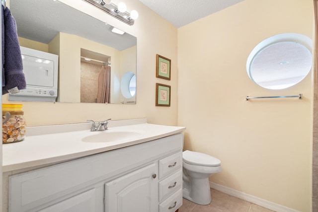 bathroom with tile patterned flooring, stacked washer and dryer, a textured ceiling, toilet, and vanity