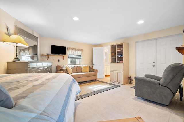 tiled bedroom with ensuite bath, a closet, and cooling unit